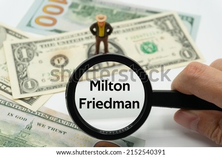 Milton Friedman.Magnifying glass showing the words.Background of banknotes and coins.basic concepts of finance.Business theme.Financial terms. Royalty-Free Stock Photo #2152540391