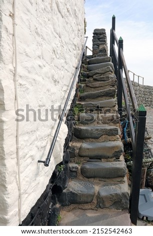 Narrow worn stone staircase, Clovelly harbour wall Devon England
