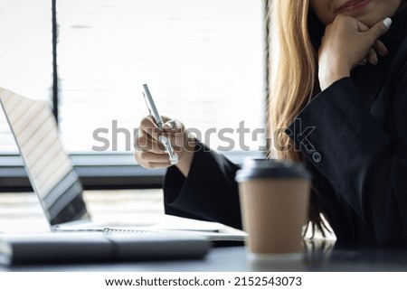 Business woman working in an office writes financial and accounting records. Accountant is working in a bank office.