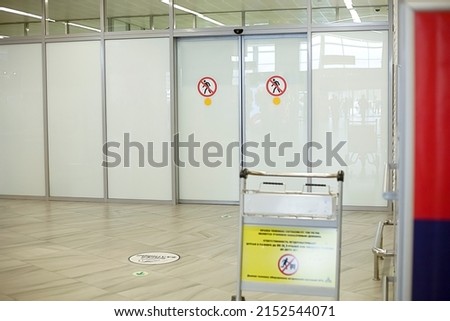 Glass doors in an airport or train station with stickers and signs. Travel, flights, meeting, seeing off.