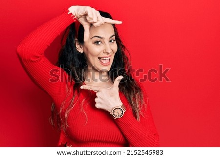 Young hispanic woman wearing casual clothes smiling making frame with hands and fingers with happy face. creativity and photography concept. 