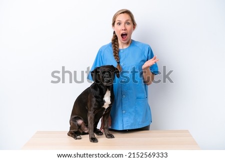 Young veterinarian woman with dog isolated on white background with shocked facial expression