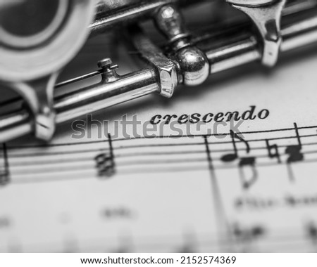 A grayscale closeup of the music instrument on the paper with the word crescendo meaning growing  Royalty-Free Stock Photo #2152574369
