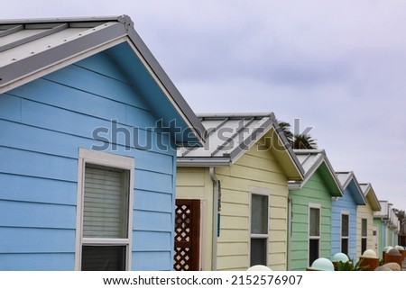 View of a row of small colorful rental cabins by the ocean with depth of field.