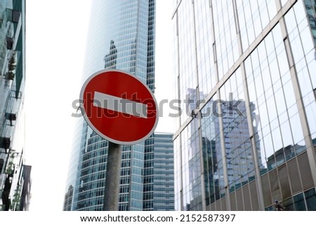 No entry sign on skyscrapers background in downtown. Concept of economic sanctions, financial crisis, global business