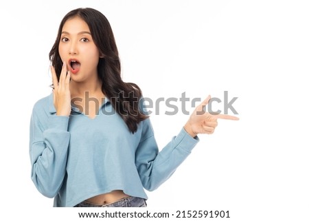 Beautiful young Asian woman pointing up to copy space and looking at camera with surprise face and excited Excited girl says wow and mouth open Use for advertising with isolated on white background