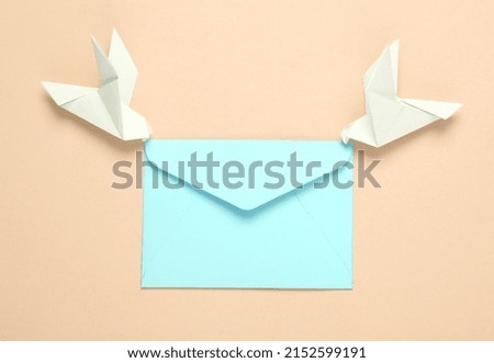 Origami carrier pigeons with envelope on yellow background