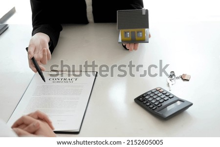 Property sales staff submit land mortgage contract documents to home buyers for sign.
