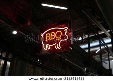 A beautiful shot of a Barbeque Neon Sign StoreFront with BBQ Pig Glowing In Marketplace
