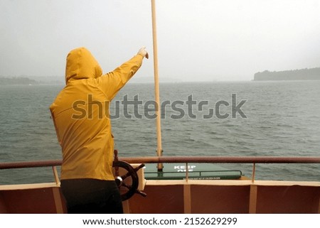 Captain in yellow cap steering