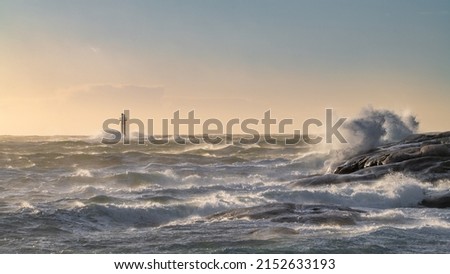 Lighthouse in windy sea with high waves Royalty-Free Stock Photo #2152633193