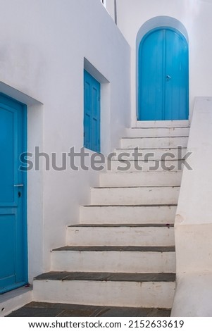 Greece. Traditional architecture in white and blue color. Greek island whitewashed building and stair, wooden door and window. 
