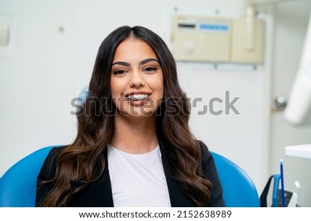 Elegant young adult woman sitting in dental chair, dental braces concept  Royalty-Free Stock Photo #2152638989
