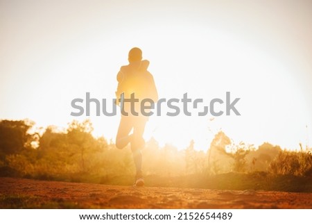 A Kenyan runner runs at sunrise in the city of Iten in Kenya. The marathoner prepares for the race in the morning. Training sports running photo