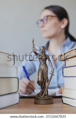 female lawyer works in the office, checking the contract and preparing documents for the court. legal advice online. european woman lawyer. bronze statuette of themis the goddess of justice and law