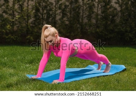 girl in a pink suit and white hair stands in the plank