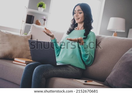 Profile side photo of young cheerful girl talk conference laptop sit divan answer courses discuss indoors