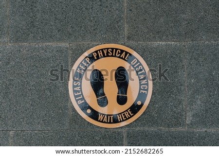 Elegant floor sign says please keep physical distance, used for health protocol in a pandemic to prevent virus.