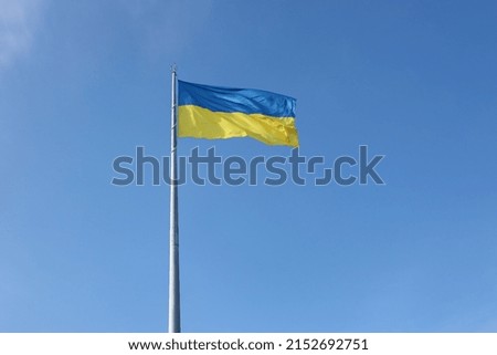 Ukrainian flag isolated on the blue sky with clipping path. Close up waving banner of Ukraine. Tall flag symbol of Ukraine, european country of freedom