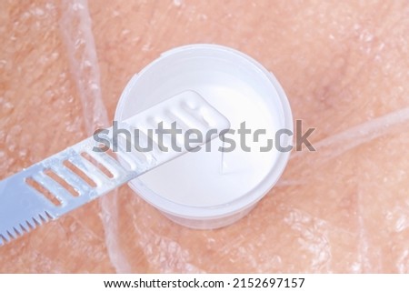 A man stirs white acrylic paint with a special plastic stirrer. Painting the door. Royalty-Free Stock Photo #2152697157