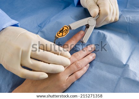 Doctor attaching pulse oxymeter to patient's finger, close-up, side view