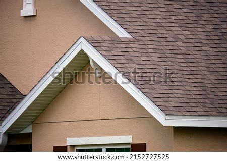 Closeup of house roof top covered with asphalt or bitumen shingles. Waterproofing of new building Royalty-Free Stock Photo #2152727525