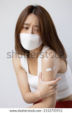 Concept image of fully vaccinated asian woman wearing face mask with side effect from vaccine shot or long covid Royalty-Free Stock Photo #2152735911