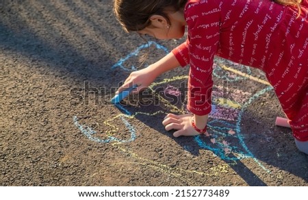 Children draw a house with chalk on the pavement. Selective focus. Kids.