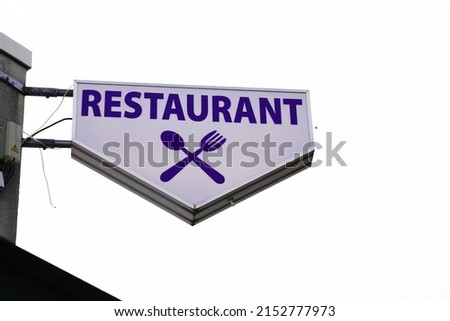 restaurant text sign on mast panel board facade building city street storefront