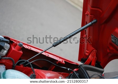 Gas bonnet strut of a new red vehicle Royalty-Free Stock Photo #2152800317