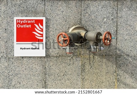 Selective focus at the sign on wall show indicates that is a fire hydrant outlet for emergency , Hydrant outlet sign and fire department connection, Fire hose connector for emergency rescue,