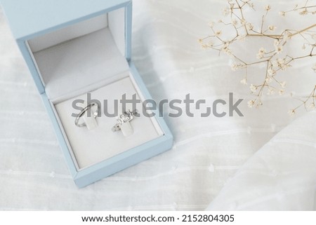 Wedding and engagement rings in a blue box set against a white background. Wedding concept image with copy space available
