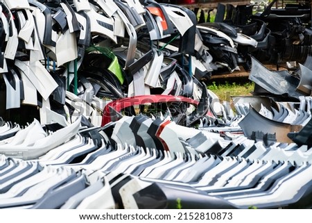 Pile of used front bumper, rear bumper, and spoiler of car for recycle. Carbon fiber, PU and PP plastic auto parts products. Automotive industry. Scrap yard of old bumper, spoiler. Plastic waste. Royalty-Free Stock Photo #2152810873