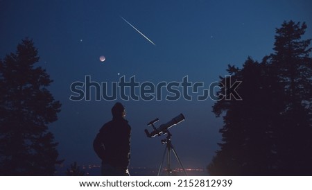 Silhouette of a man, telescope, stars, planets and shooting star under the night sky. Royalty-Free Stock Photo #2152812939
