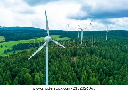 Renewable energy. Wind power plant in the bright green field with fir forest near Titisee-Neustadt. Black forest, Germany.