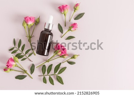 cosmetic oil, essential oil or self-care serum in bottle on a purple background with fresh flowers. natural cosmetics