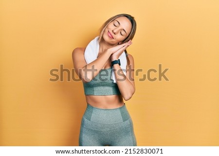 Beautiful hispanic woman wearing sportswear and towel sleeping tired dreaming and posing with hands together while smiling with closed eyes. 