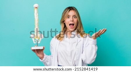 pretty blonde woman feeling happy and astonished at something unbelievable. spine specialist concept