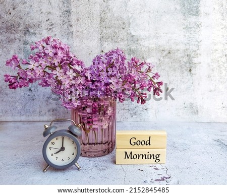 Alarm Clock ,Good Morning Message on wooden cubes and Purple Lilac Flowers 
