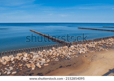 Breakwater wooden structures with blue sea and sky in the background. Stock photography