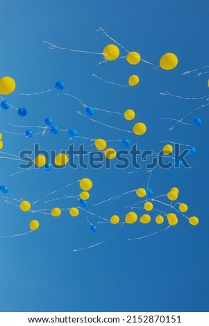 Blue and yellow balloons on blue sky background
