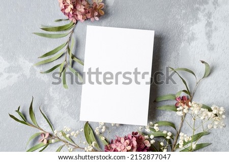 Wedding invitation or greeting card mockup with eucalyptus and hydrangea flowers decorations.