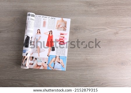 Open magazine on wooden table, top view. Space for text Royalty-Free Stock Photo #2152879315