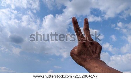 Photo of a hand showing two fingers.