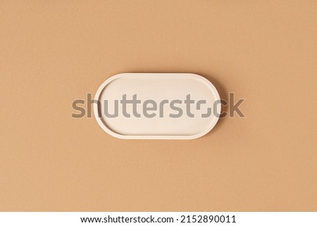 Podium for cosmetic product presentation. Abstract minimal geometrical form on beige background. Oval stone form. Scene, Showcase, display. Minimal design. Soft shadow. Flat lay, Top View. Copy space