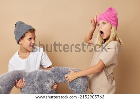 Portrait of cute children standing next to posing toy emotions isolated background
