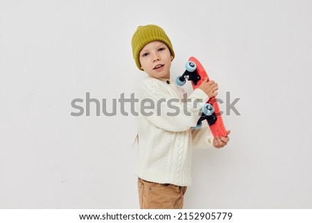 cute girl in hats with a skateboard in their hands light background