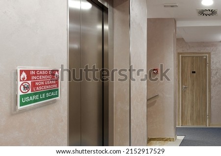 Emergency sign: in case of fire don't use the elevator, use the stairs. Safety sign concept, plexi sign on the wall.