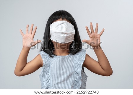 Portrait of funny Asian girl kid with protective face mask. Concept of kid going back to school and new normal lifestyle