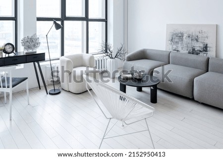 modern minimalistic interior design of light bright monochrome room with black and white furniture, clean white walls and huge windows